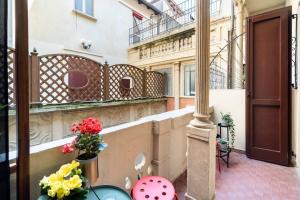 a balcony with flowers in pots on a building at Appartamento elegante e centrale La Foglia D'Oro in Bologna