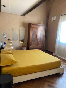 a bedroom with a large yellow bed with a window at Olivietta Suite in Cervia
