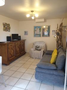 ein Wohnzimmer mit Sofa und Tisch in der Unterkunft Le Clos des Mimosas in Saint-Andéol-de-Vals