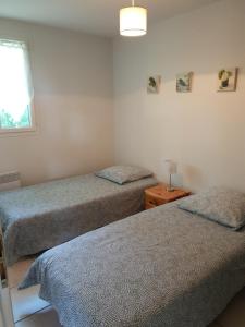 ein Schlafzimmer mit zwei Betten und einem Fenster in der Unterkunft Le Clos des Mimosas in Saint-Andéol-de-Vals + 30 Fotos