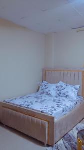 Bett in einem Zimmer mit einer weißen Wand in der Unterkunft Sojah Apartment in Daressalam