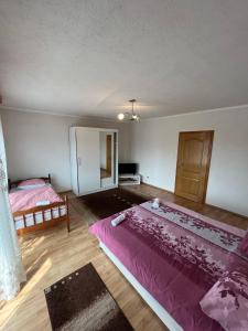 1 Schlafzimmer mit 2 Betten und einer rosa Decke in der Unterkunft Apartmani Hadžić in Živinice