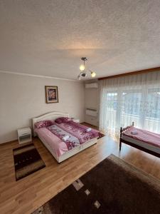 a bedroom with a large bed and a window at Apartmani Hadžić in Živinice