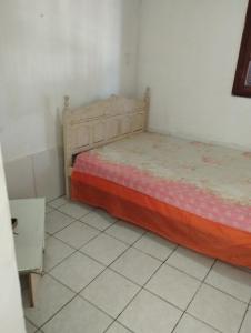 1 dormitorio pequeño con 1 cama y suelo de baldosa en Sítio da amizade casa piscina churrasqueira, en Búzios