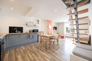 cocina y comedor con mesa y sillas en Duplex Petit-Fort - proche plage, en Gravelines