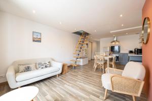 a living room with a couch and chairs and a kitchen at Duplex Petit-Fort - proche plage in Gravelines