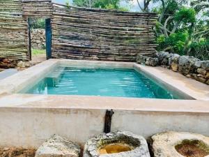 une piscine d'eau dans une arrière-cour avec une clôture dans l'établissement Casa de campo y arte en Zona Arqueológica Ake, con alberca., à Aké
