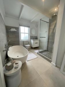 łazienka z wanną, toaletą i prysznicem w obiekcie Stunning Beach House in Grotto Bay w mieście Grotto Bay