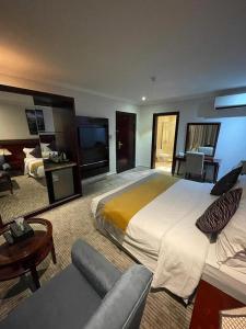 a hotel room with a large bed and a couch at تـالـيـن الـهـفـوف in Al Hofuf