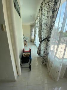 un corridoio con una sedia in una stanza con finestra di Daffodil Homestay in Perlis a Kangar