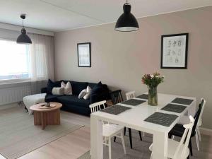 ein Wohnzimmer mit einem weißen Tisch und einem blauen Sofa in der Unterkunft 3 h + keittiö ja parveke, juuri remontoitu! in Lahti