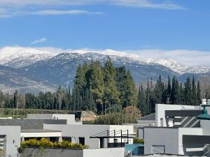 a white building with snow covered mountains in the background at מון-שיר הגושרים in Hagoshrim