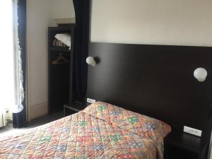 een slaapkamer met een bed met een kleurrijke sprei bij Hotel de la Basilique in Paray-le-Monial