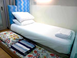 a unmade bed with towels on top of it at Big & Modern Condo with a Wide Balcony & Free Netflix in Manila