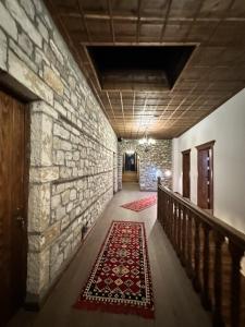 einen Flur mit einer Steinmauer und einem Teppich auf dem Boden in der Unterkunft Koroni Boutique Hotel in Berat