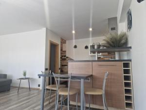 cocina y comedor con mesa y sillas en Duplex Apartment Vilte, en Druskininkai