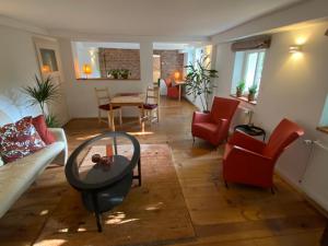 sala de estar con sillas rojas y mesa en Historisch Pand, en Spechtholzhock