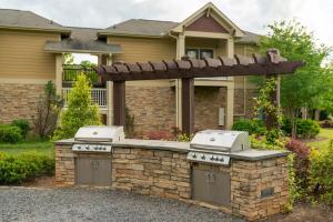 a barbecue grill in front of a house at Adorable apartment w/ pool view in Charlotte