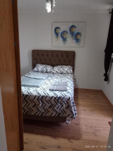 uma pequena cama num quarto com piso em madeira em Ap ótima localização em São José dos Campos