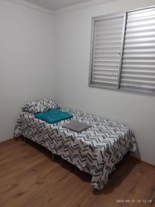 a bed sitting in a room next to a window at Ap ótima localização in São José dos Campos