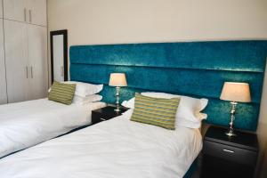A bed or beds in a room at Vredenburg Boutique Lodge