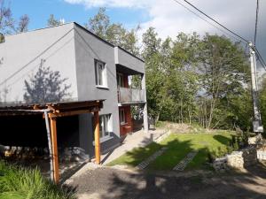 una casa gris con una puerta roja y un patio en Dovolenkový dom Nika en Vinné