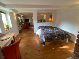 um quarto com uma cama e piso em madeira em Historisch Pand em Spechtholzhock