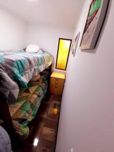 ein kleines Zimmer mit einem Bett und einer Lampe auf dem Boden in der Unterkunft Cabañas Garcia in Algarrobo