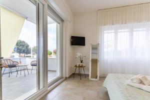 een slaapkamer met een bed en een glazen schuifdeur bij Doctor Guest House in Tortolì