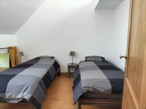 two beds sitting next to each other in a bedroom at Gite rural La Ferme du Semeur-Zaaiershof in Lessines