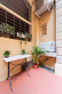 a table sitting outside of a building with potted plants at Central and cozy loft with courtyard in Bologna