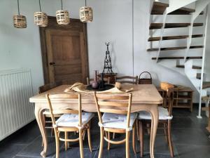 una sala da pranzo con tavolo e sedie in legno di Gite rural La Ferme du Semeur-Zaaiershof a Lessines