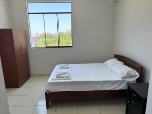 a bedroom with a bed and a window at Casa Mimaya in Piura