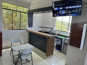 a kitchen with a counter and a table and chairs at Casa Mimaya in Piura