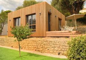 a small wooden house with a stone wall at La Villa d’Emma in Mougins