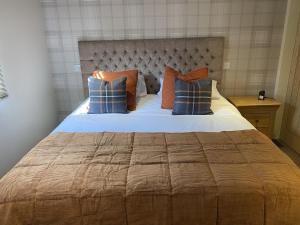 sypialnia z dużym łóżkiem z niebieskimi i pomarańczowymi poduszkami w obiekcie Lochindaal Hotel w mieście Port Charlotte