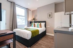 - une petite chambre avec un lit et une fenêtre dans l'établissement Fulham Studio Apartments, à Londres
