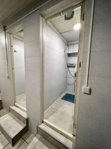 - Ducha a ras de suelo con puerta de cristal en una habitación en InJoy Hostel en Shymkent