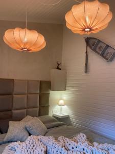 a bedroom with a bed with two lights and two lamps at Chalet Maurice in Zutendaal