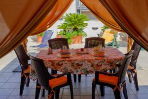 uma mesa com cadeiras e uma toalha de mesa num pátio em Vuemme 97 em Bari