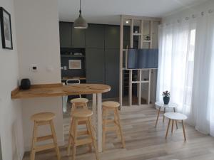 eine Küche mit einem Tisch und einigen Hockern in der Unterkunft cosy appartment - Clamart Percy Paris in Clamart