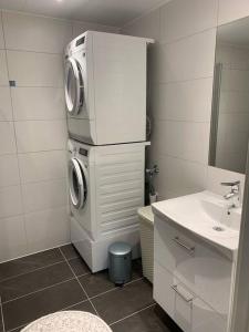 uma casa de banho com uma máquina de lavar roupa e um lavatório em Rom m/bad i Bodø sentrum em Bodø