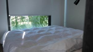 a white bed in a bedroom with a window at Cabañas y Padel Tinycolchagua cl in Santa Cruz +16 photos