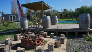 a fire pit in a yard with logs and large pots at Cabañas y Padel Tinycolchagua cl in Santa Cruz