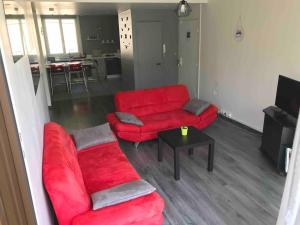un salon avec un canapé rouge et une table dans l'établissement Lumineux / vue sur parc thermal, à Chamalières