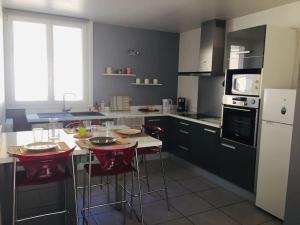 une cuisine avec une table avec des chaises et un micro-ondes dans l'établissement Lumineux / vue sur parc thermal, à Chamalières