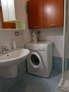 ein Badezimmer mit einer Waschmaschine und einem Waschbecken in der Unterkunft Appartamenti Top Life in Arco