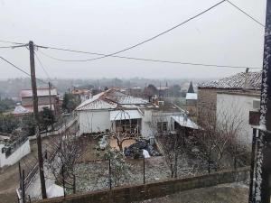 uma vista para uma cidade com telhados cobertos de neve em Archontiko Kastellia em Evangelístria