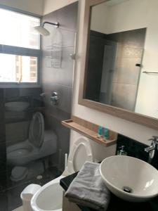 a bathroom with a sink and a toilet and a mirror at 19TH FLOOR LUXURY APARTMENT BAY VIEW CARTAGENA in Cartagena de Indias