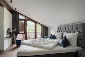 um quarto com uma cama grande e almofadas azuis em Ansitz Battisti Suites em Caldaro